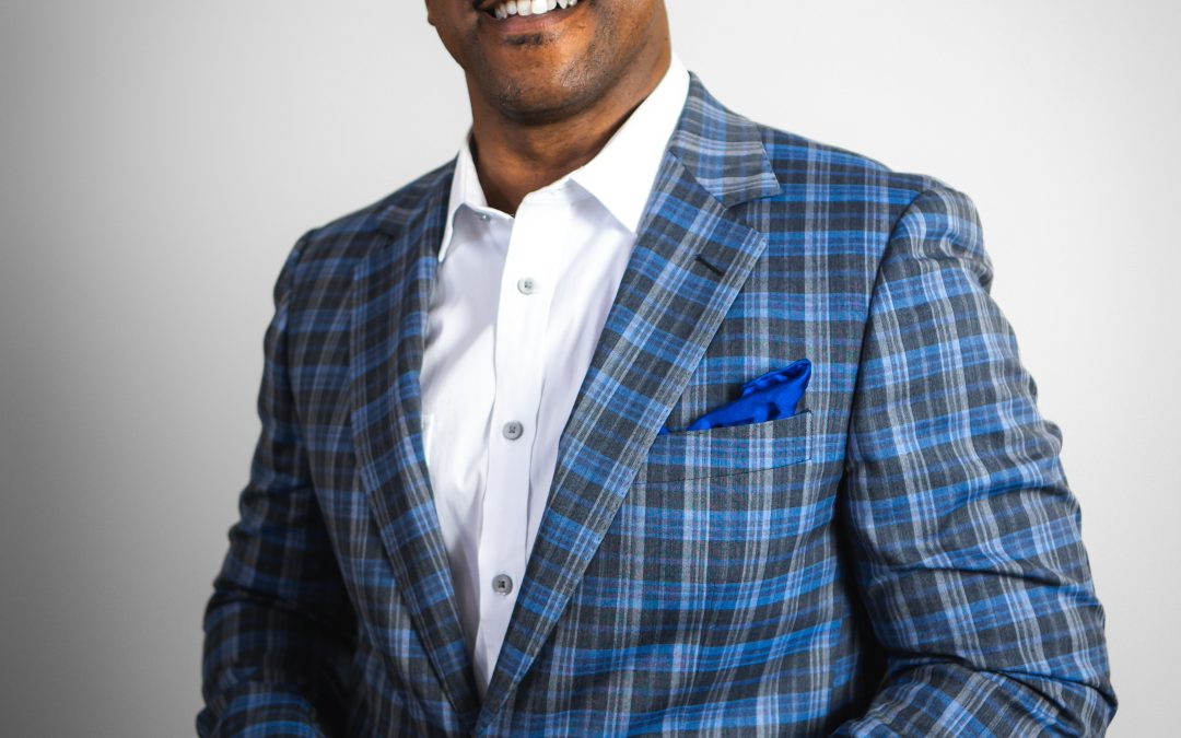 Headshot of Barron Damon, Philanthropic Coach, wearing a checkered blue blazer, white shirt, black hair, and glasses.