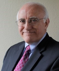 Headshot of George Scott - male wearing dark suit with red tie