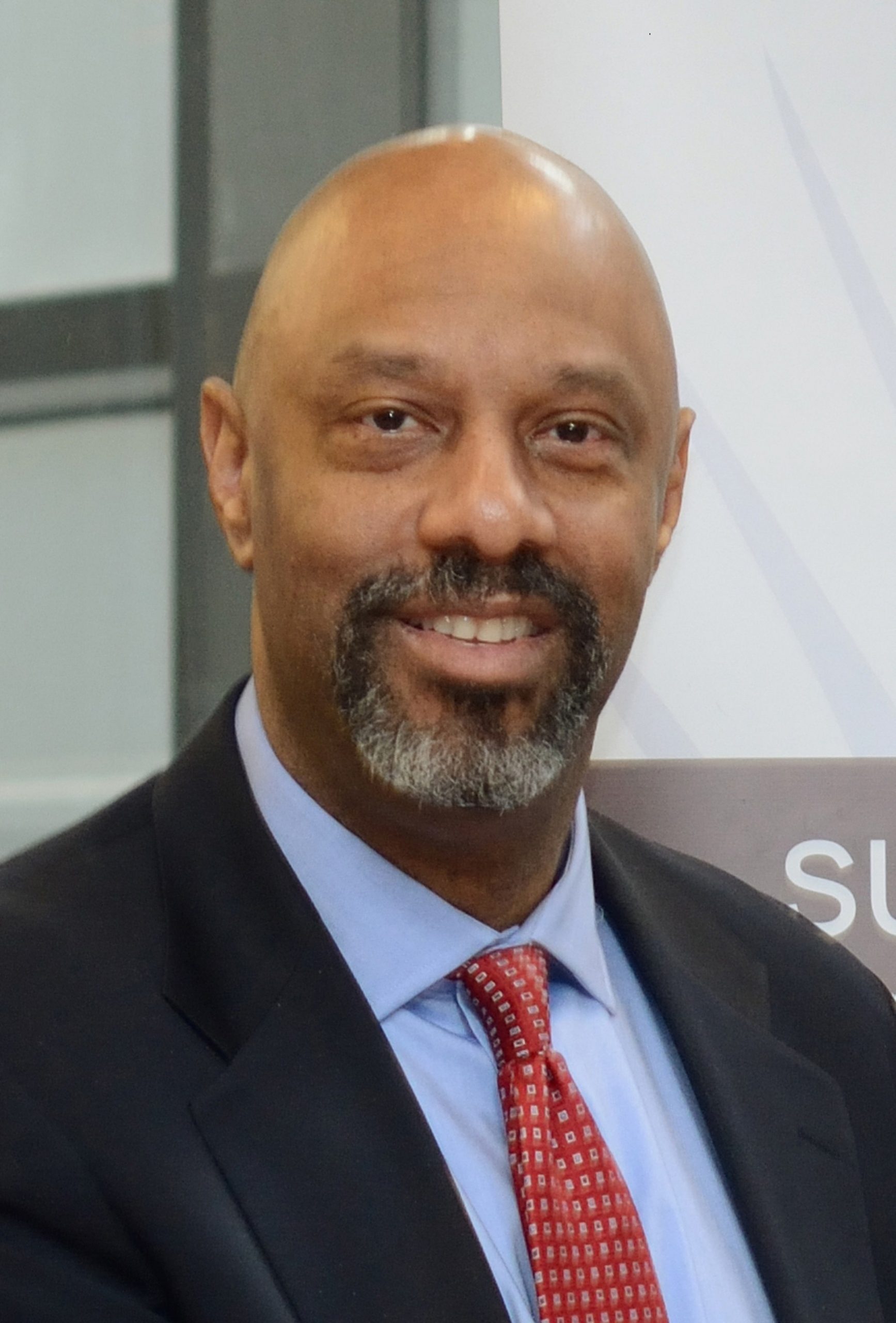 Headshot of Andrew Frazier- male wearing light blue shirt and red tie smiling