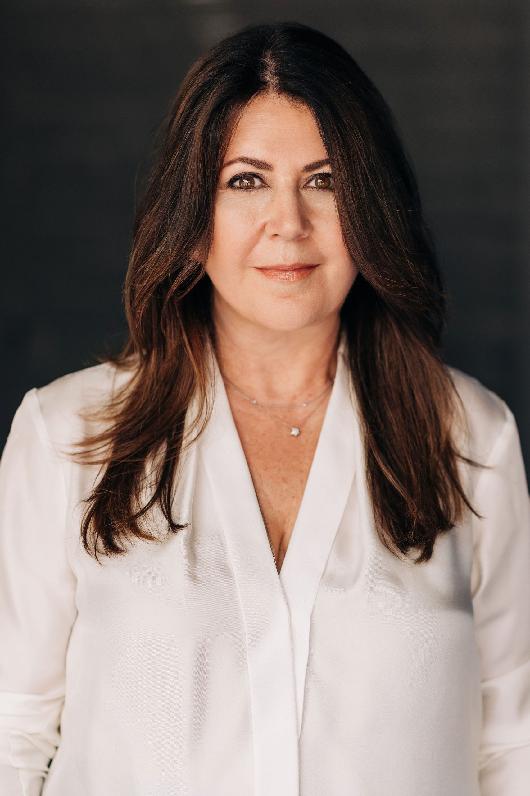 Headshot of Heather Smith - woman with long brown hair wearing white blouse