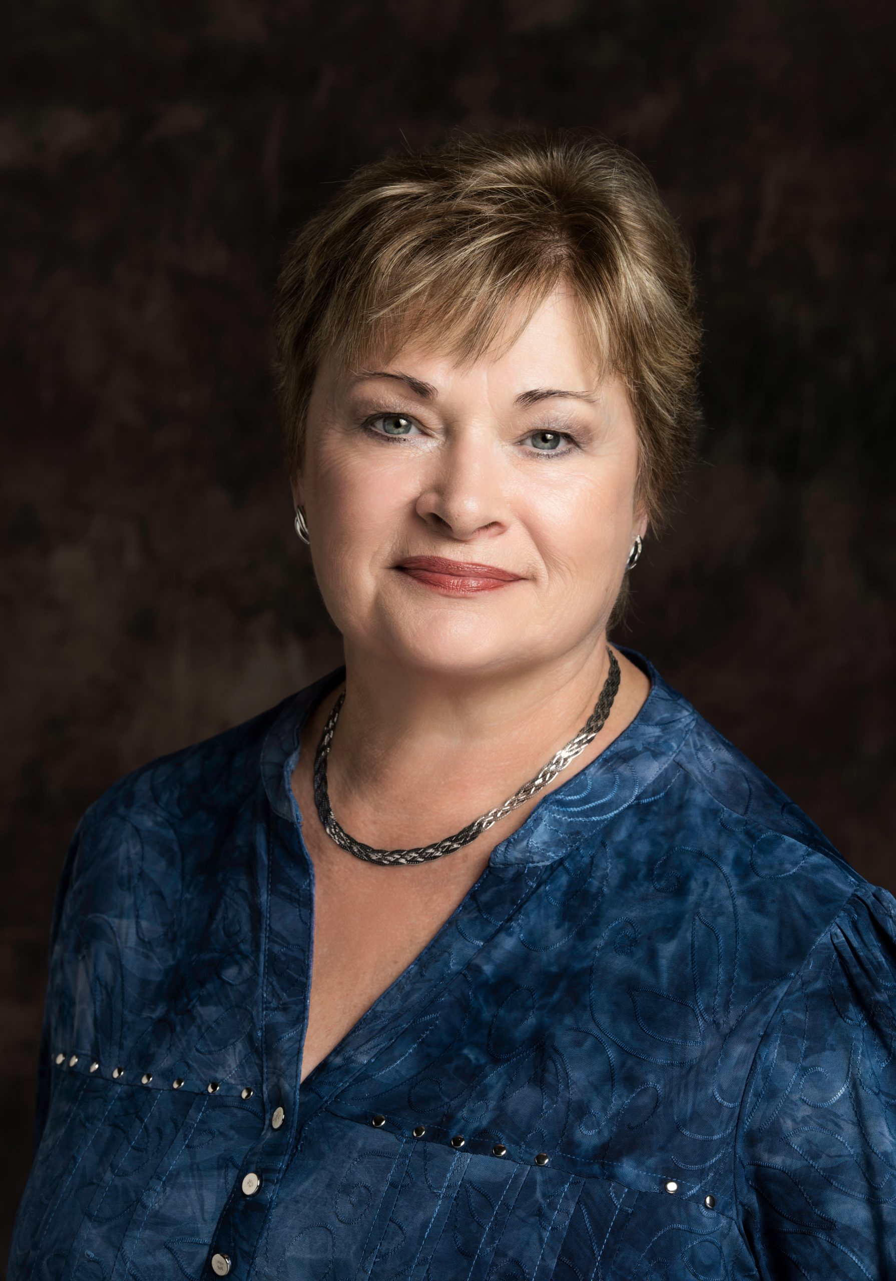 Lorraine Lane headshot - a white woman with short brown hair wearing a blue blouse