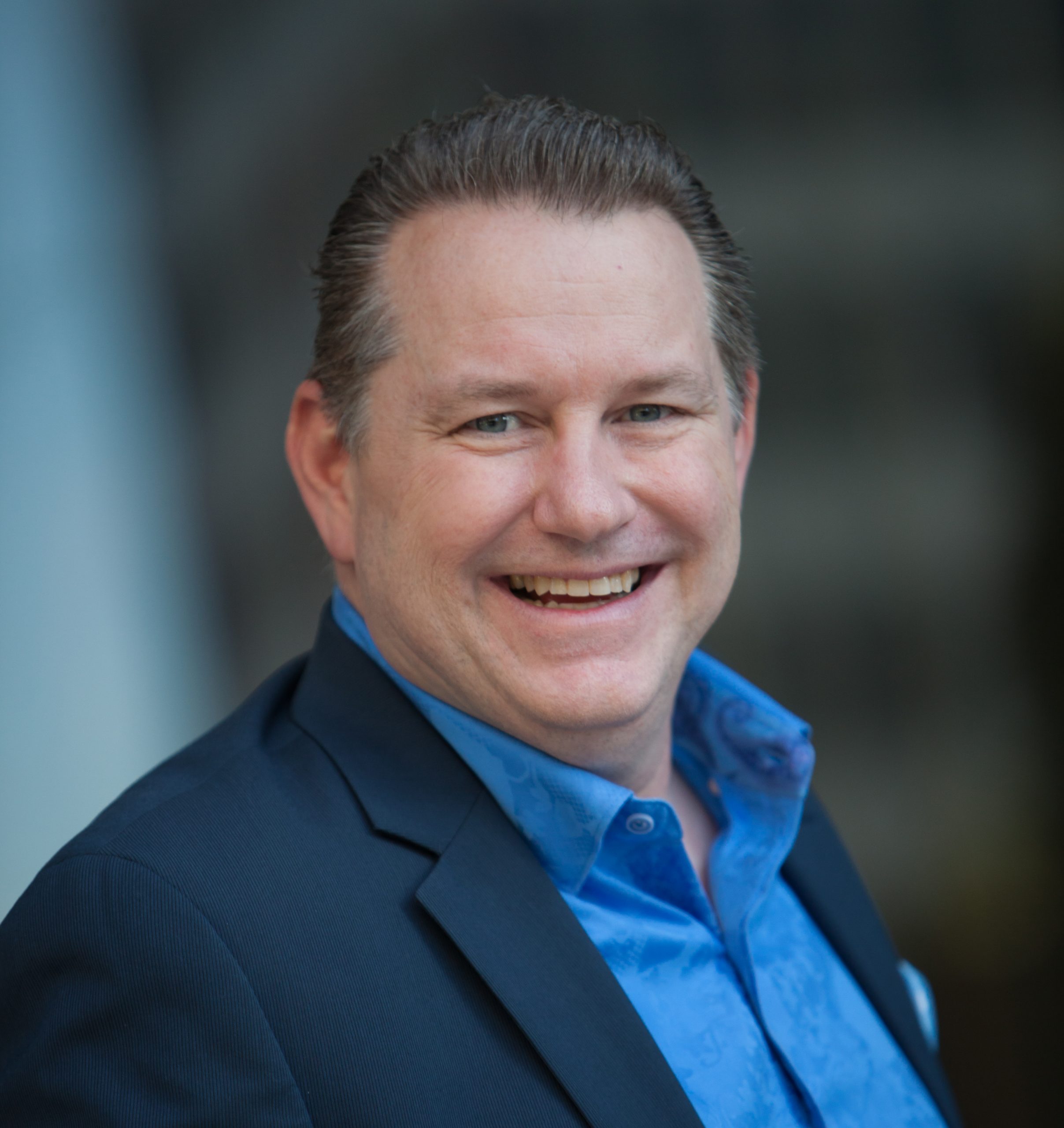 Headshot of Mike Driggers  - male with brown hair wearing blue suit