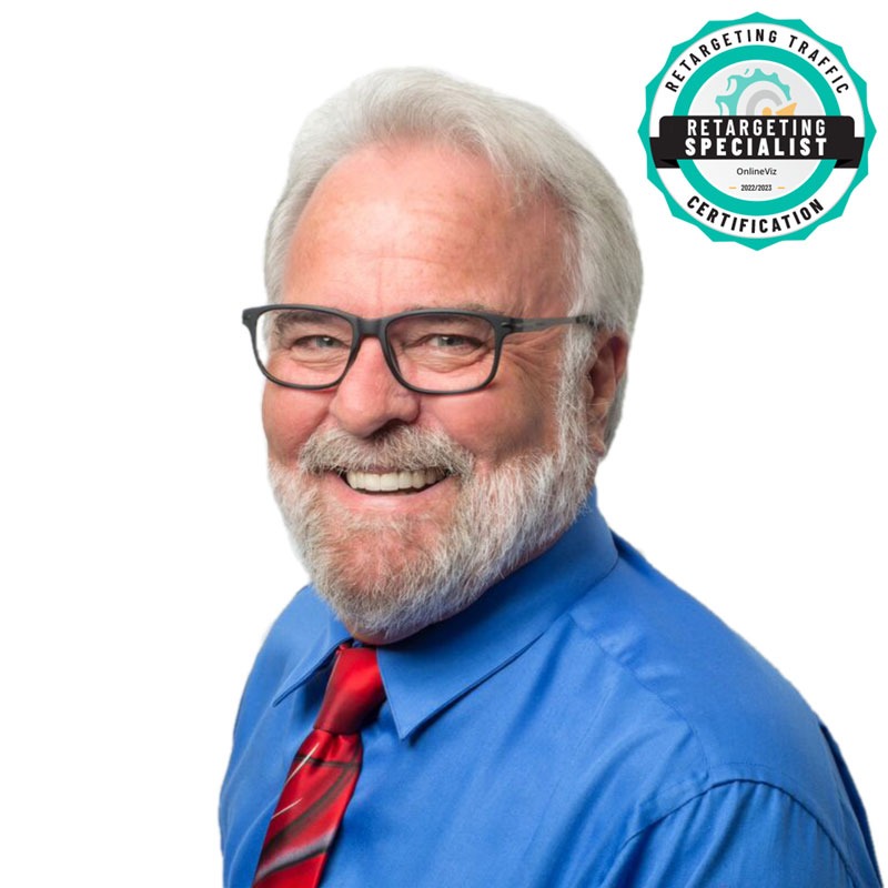 Side headshot of Patrick Smith - male wearing blue shirt and red tie wearing glasses smiling