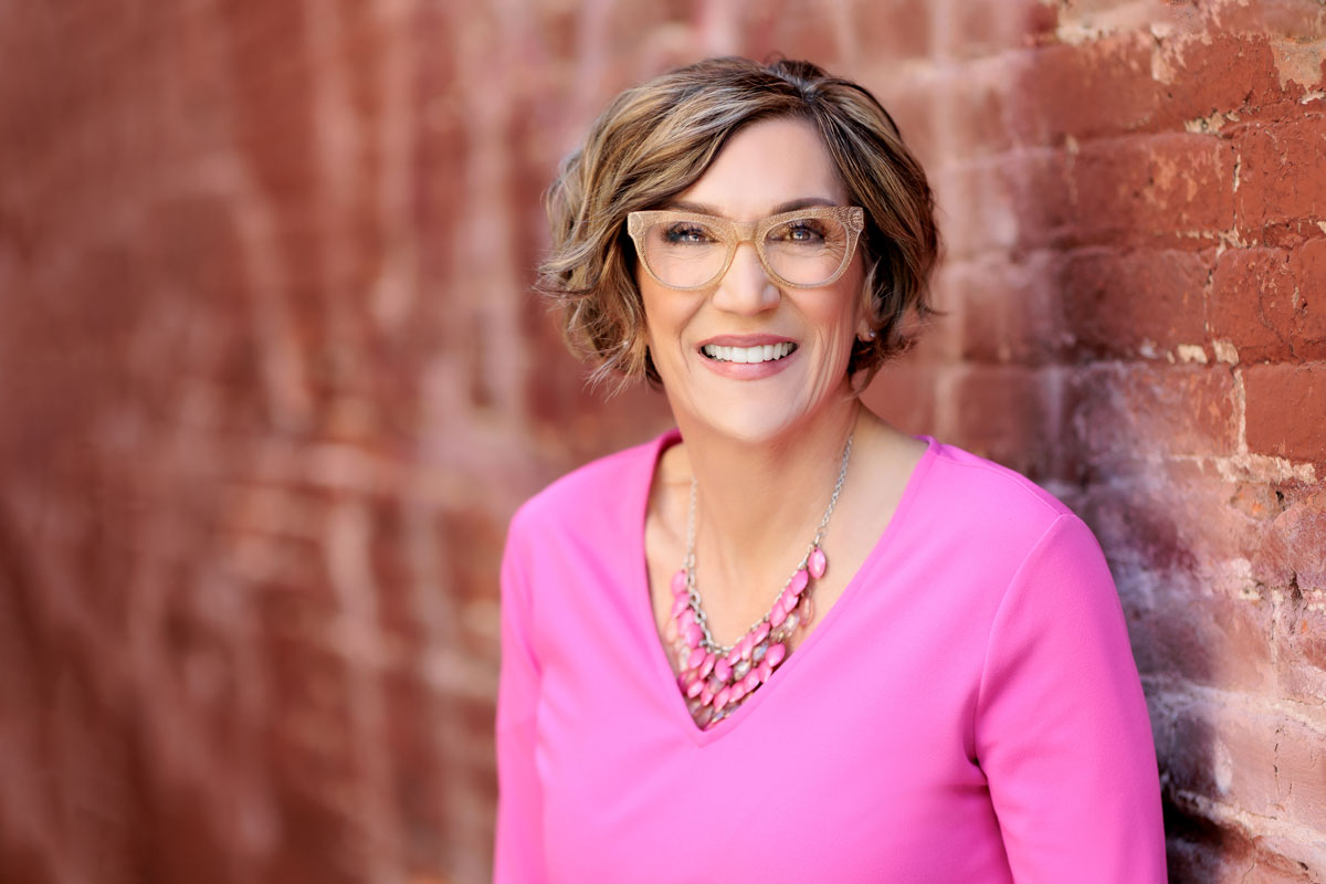 Headshot of AI Keynote Speaker, Susan Frew wearing a pink blouse