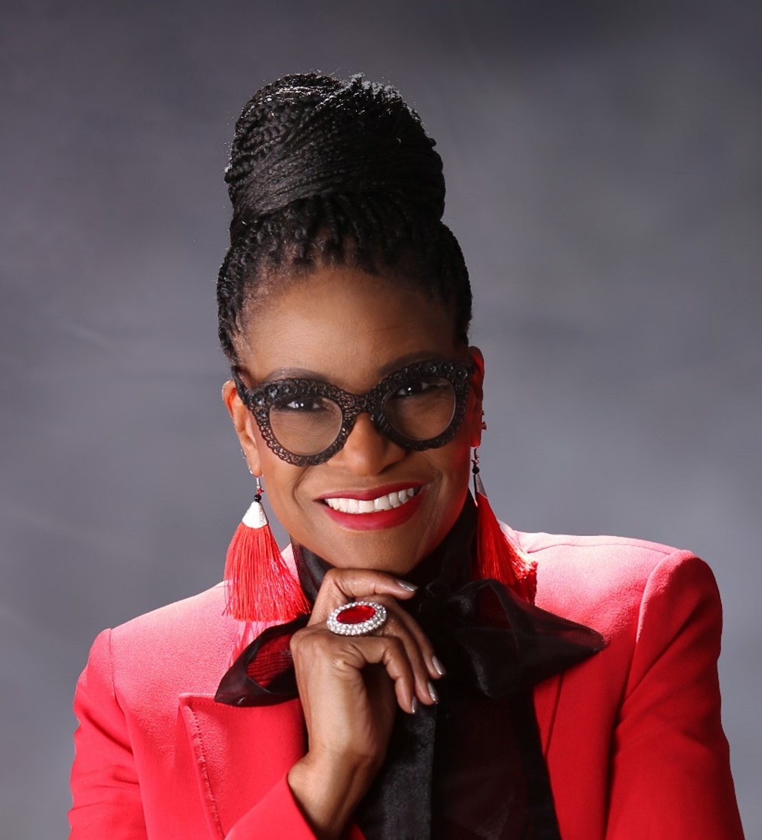 Headshot of Toni Harris Taylor - woman wearing red blazer smiling with hand under chin