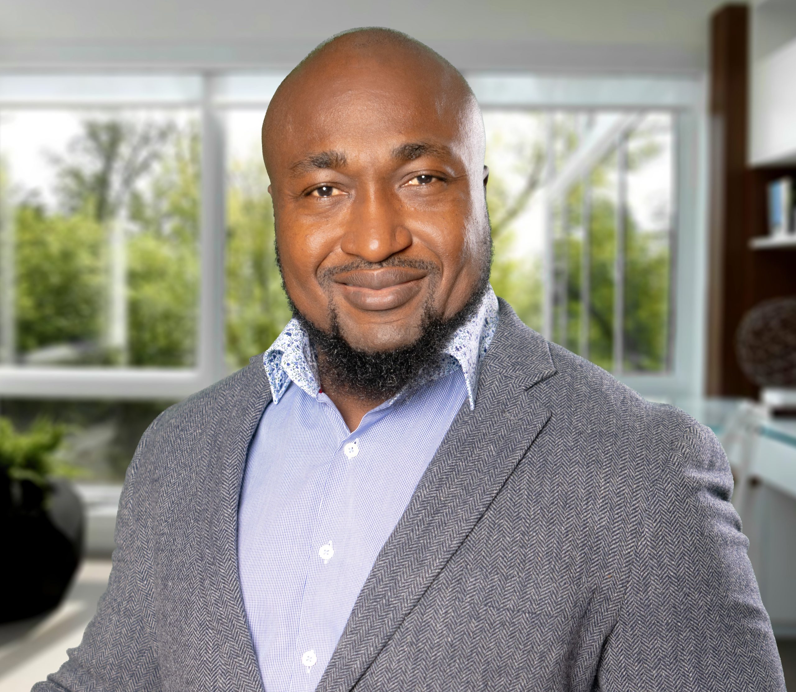 headshot of Funso Richard, bald man with beard, wearing a gray suit
