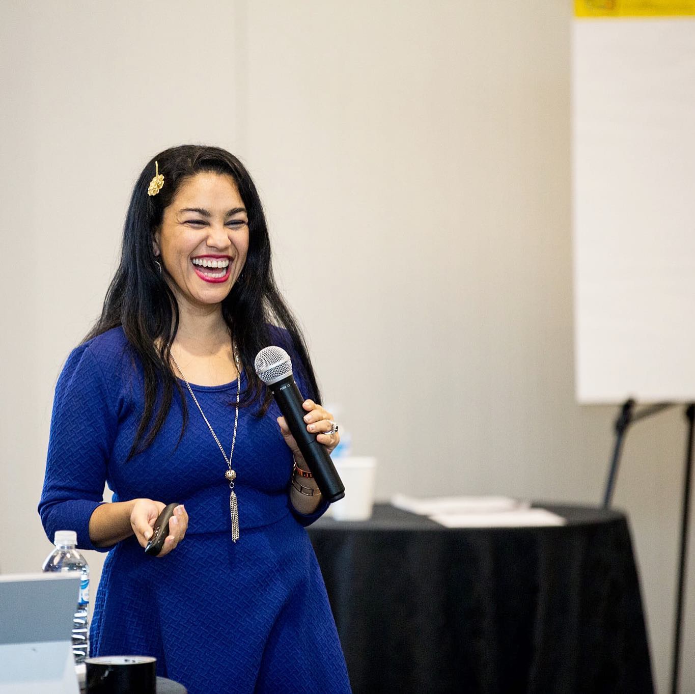 Headshot of Elayna Fernández - Woman wearing blue dress smiling while speaking